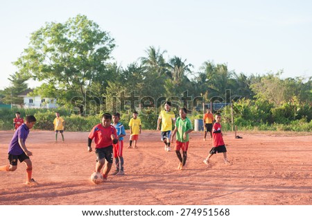 SURATTHANI THAILAND- Mar 25: Local kids enjoy playing football on dust field after school. Mar 25,2014 in suratthani province,Thailand