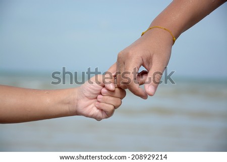 children hands over blue water outdoor, summer kids vacation concept