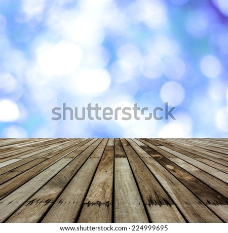 Empty perspective wood with blur blue leaves bokeh background, for product display montage