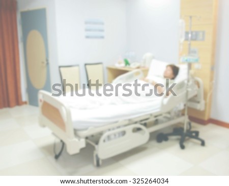 blurred image of Patient with drip in hospital for background usage .