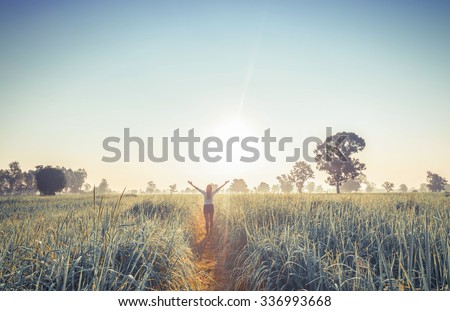 Women enjoying nature in meadow. Outstretched arms fresh morning air summer Field at sunrise.