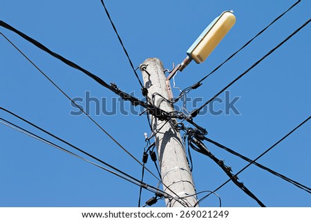 Electrical wire on pole. chaotic wire with nest on pole and blue sky background