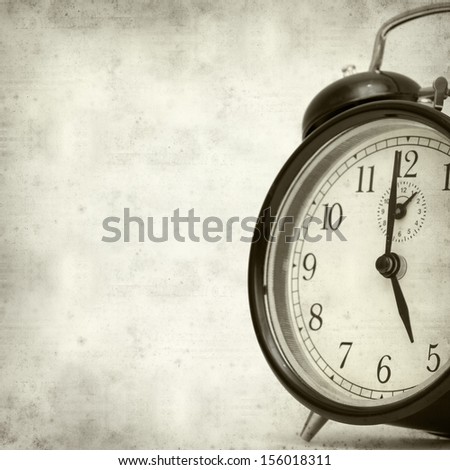 textured old paper background with old fashioned alarm clock