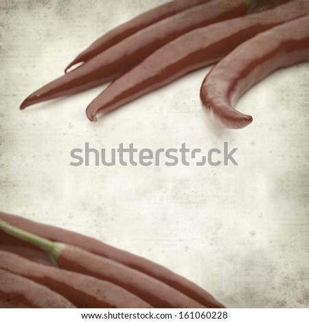 textured old paper background with red hot chili pepper