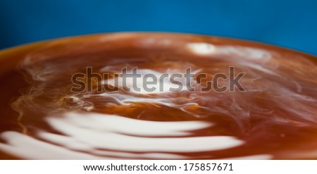 coffee with milk - a drop of milk going into hot coffee