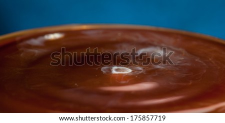 coffee with milk - a drop of milk going into hot coffee
