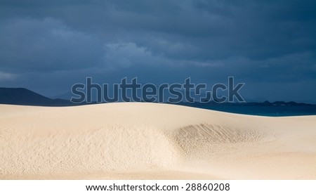 Fuerteventura, Corralejo sand dunes nature park, sand dunes in the sun, overcast ocean in the background
