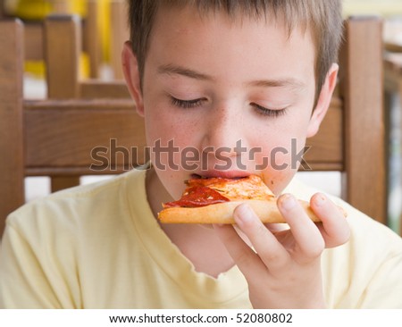 my piece of pizza - cute little caucasian boy eating pizza; face somewhat dirty with tomato sauce