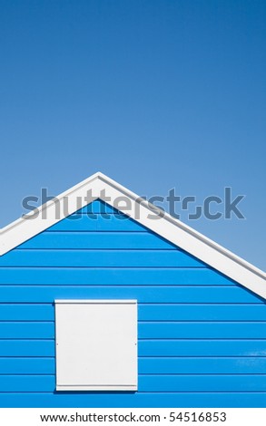 bright blue colored; beach hut with white trim; under blue sky
