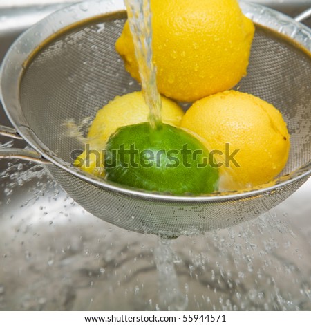 washing lemons and lime in a sieve