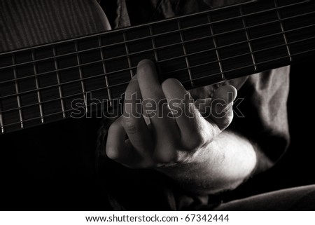 G major chord on six-string electric bass guitar (left hand), toned monochrome image