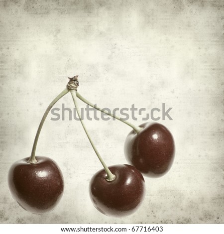 textured old paper background with red ripe shiny cherry fruit