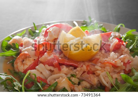 freshly made steaming hot seafood paella served on a bed of wild rocket salad