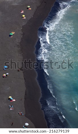 Black sand beach abstract, shot from above
