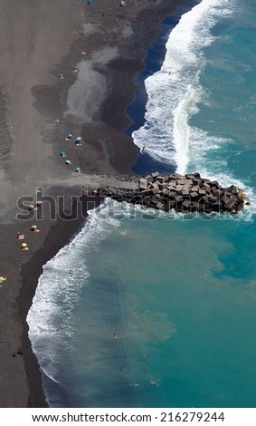 Black sand beach abstract, shot from above