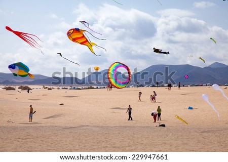 FUERTEVENTURA, SPAIN - NOVEMBER 08: Viewers watch from the ground as multicolored kites fill the sky at 27th International Kite Festival, November 08, 2014 in Dunes of Corralejo, Fuerteventura, Spain