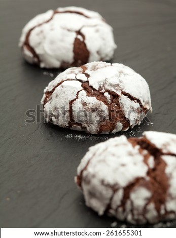 freshly made chocolate biscuits coated in icing sugar on a slate trivet