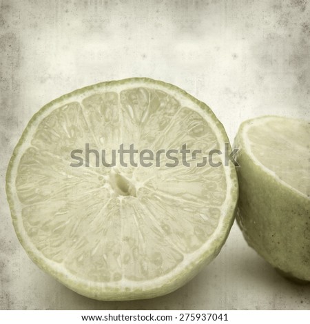 textured old paper background with cut lime fruit