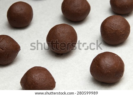 making chocolate cookies - small balls of chocolate mix on baking parchment