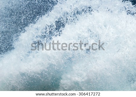 sea water foam flying against the backdrop of blue water