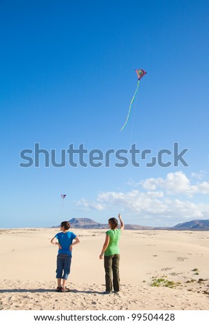 mother and son fly a kite at natural reserve dunes of Corralejo, Fuerteventur, Canary Islands