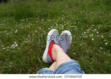 Feet in sneakers in flower field