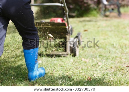 A worker uses a  grass cutter to trim the lawn,