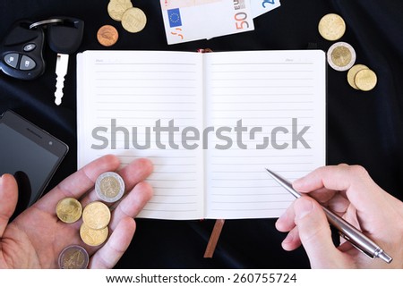 hand with pen ready to write on a notepad on a black background