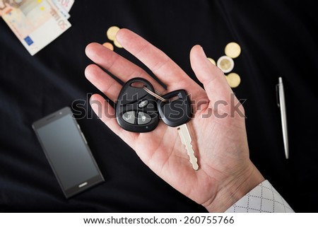 car keys on the man\'s palm on a black background