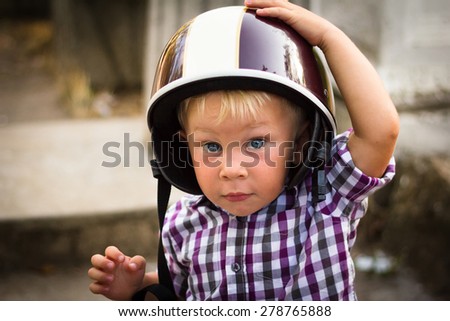 Blond boy with motorbike helmet, safety concept