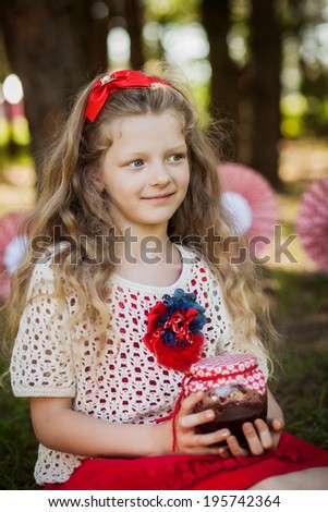 Portrait of a little girl with a jar of jam