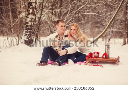 cute couple resting in a snowy forest