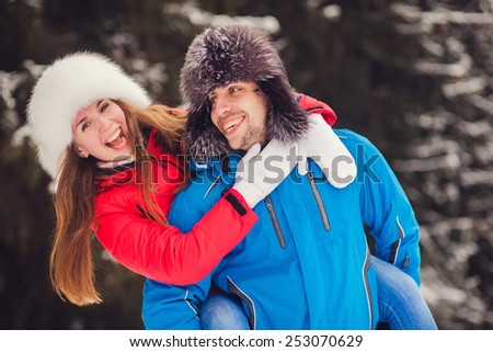 Winter fun couple playful together during winter holidays in park