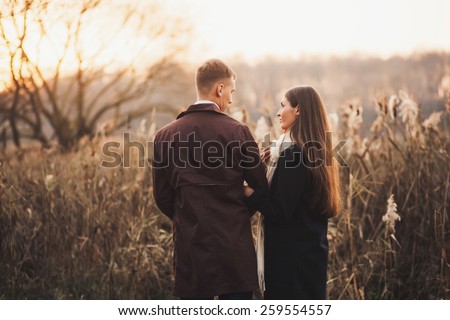 Sweet couple standing holding hands at sunset. Evening portrait of lovers