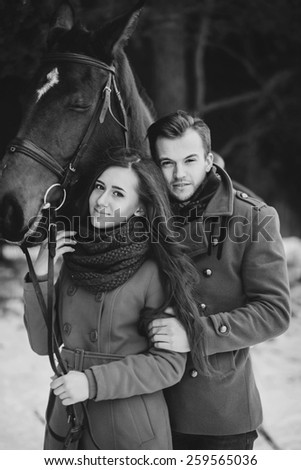 Fashion portrait of young sensual couple and horse. Black and white picture