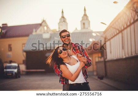 smiling couple in sunglasses having fun in city. love and friendship.