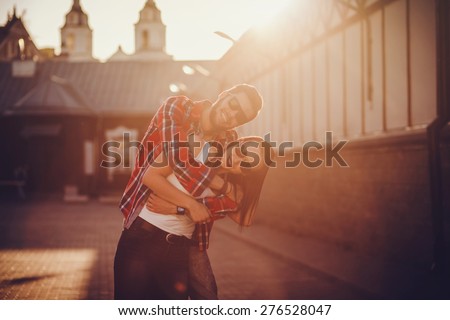Young and funny couple have fun in sunny day. sunset