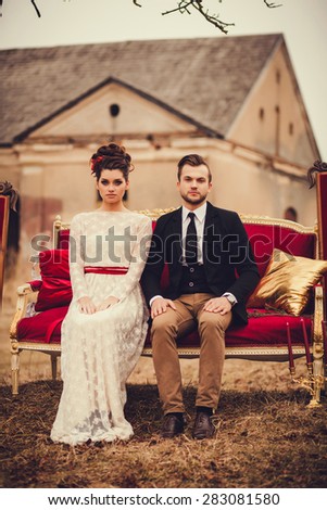 Romantic couple sitting on the couch and looking at the camera