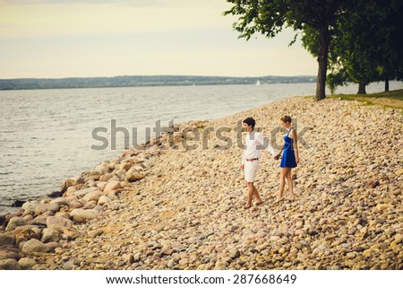 young couple walking along the beach at sunset. happy weekend