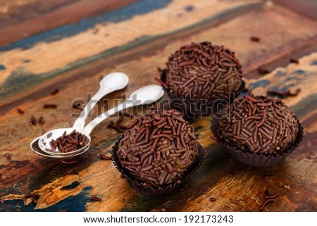 Brazilian chocolate  truffle bonbon brigadeiro with spoon on wooden table. Selective focus