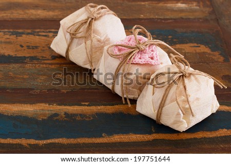 Three Brazilian wedding sweets bem casado with pink crochet heart on wooden table. Selective focus. Copy space