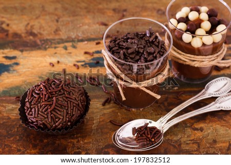 Brazilian chocolate bonbon truffle brigadeiro in glass with spoon on wooden table