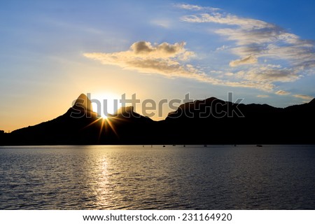 Sunset Lagoon Rodrigo de Freitas (Lagoa), sun behind mountain Two brothers, Stone of Gavea, Rio de Janeiro, Brazil