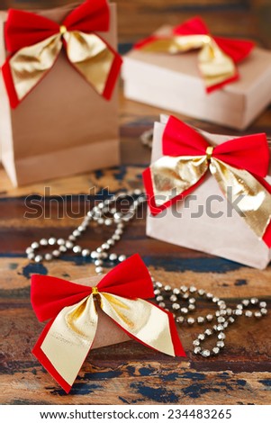 Christmas gifts paper package with red golden bow. Selective focus on first bow