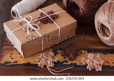 Brown crochet snowflakes for Christmas decoration of gift box. Selective focus
