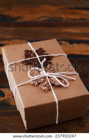 Christmas gift box with handmade brown crochet snowflakes. Selective focus