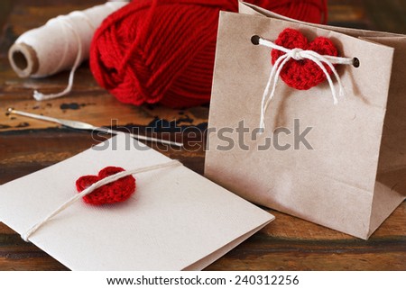 Saint Valentine decoration: handmade crochet red heart for greetings card and gift package. Selective focus
