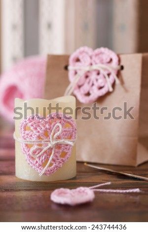 Saint Valentine decoration: handmade crochet pink heart for candle and gift paper package. Selective focus