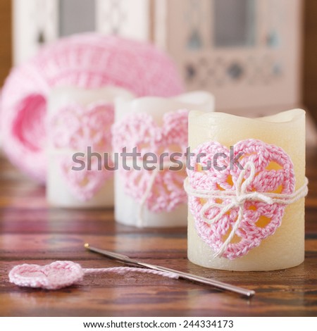 Handmade crochet pink heart on candle for Saint Valentine\'s day with skein. Selective focus