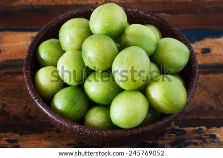 Brazilian fruit Spondias tuberosa (Brazil plum, imbu, umbu) in bowl on table. Selective focus